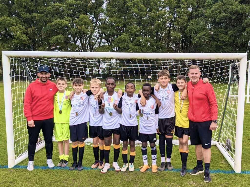 group of school boys wearing medals and football kits