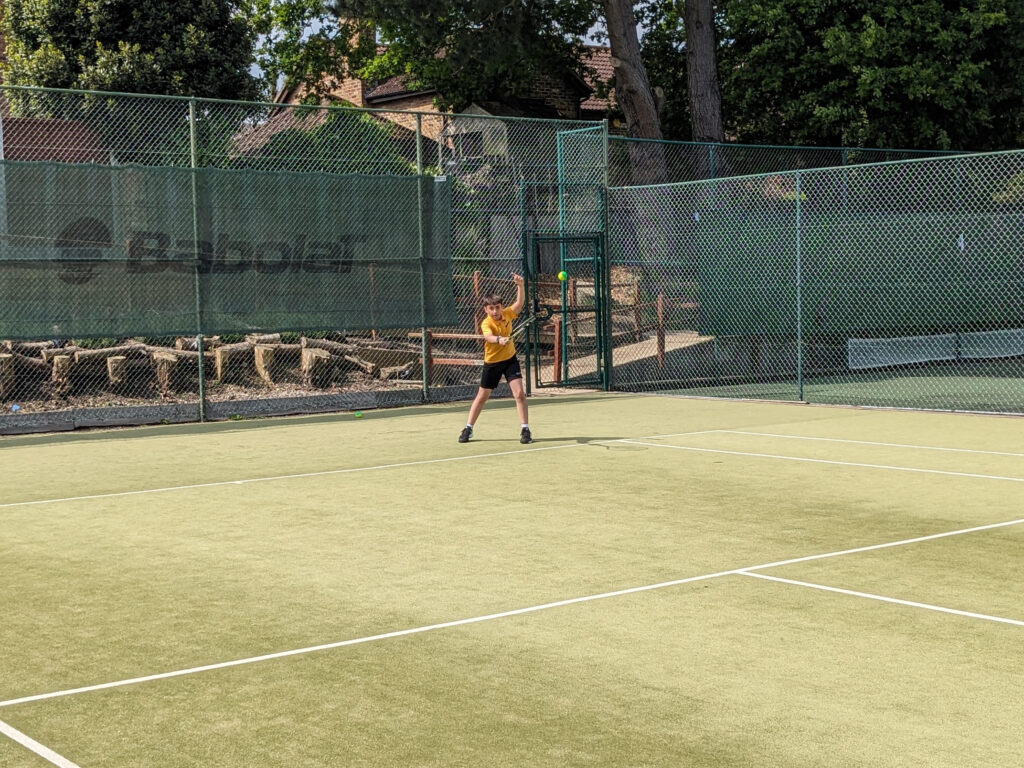 student playing tennis